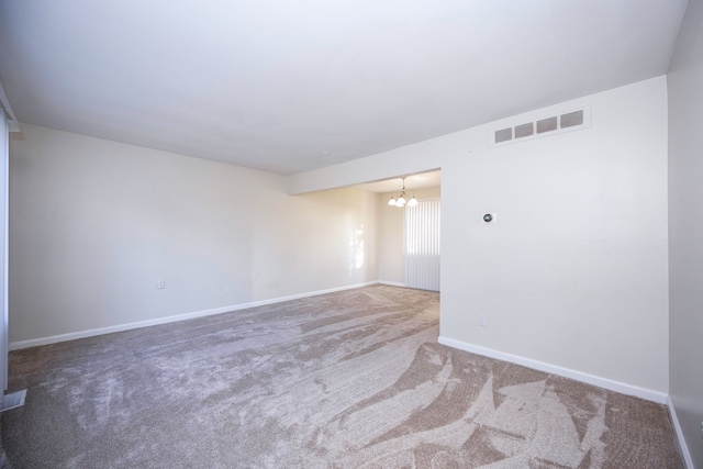 unfurnished room with carpet floors and a notable chandelier