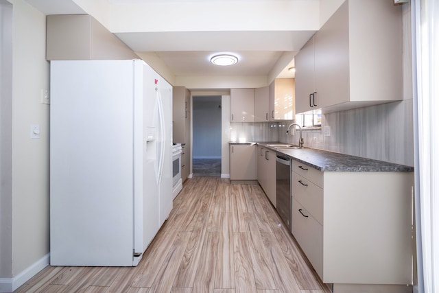 kitchen featuring backsplash, white appliances, sink, light hardwood / wood-style flooring, and white cabinets