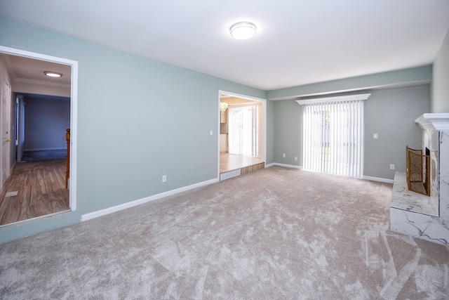 unfurnished living room with a fireplace and light colored carpet