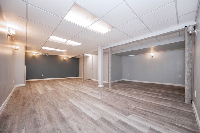 basement with hardwood / wood-style flooring and a drop ceiling