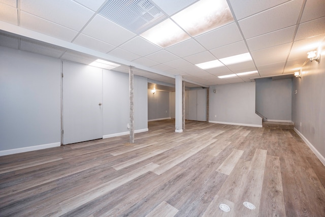 basement featuring light hardwood / wood-style floors and a drop ceiling