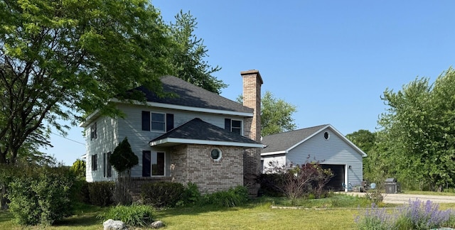 2702 E Hoague Rd, Michigan, MI 49411 - back of property featuring a chimney, a garage, a yard, brick siding, and an outdoor structure