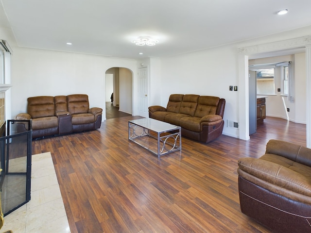 living room with a tiled fireplace and dark wood-type flooring