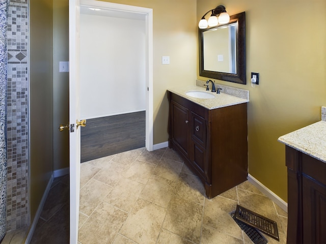 bathroom with a tile shower, hardwood / wood-style floors, and vanity