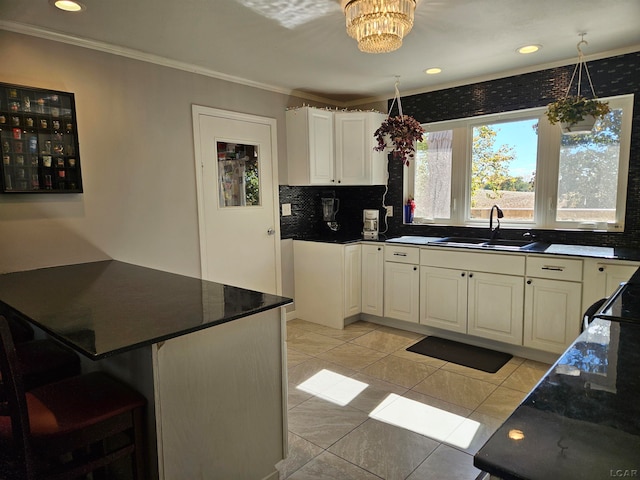 kitchen with decorative backsplash, light tile patterned floors, a notable chandelier, and sink