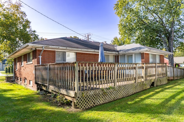 back of property featuring a lawn and a wooden deck