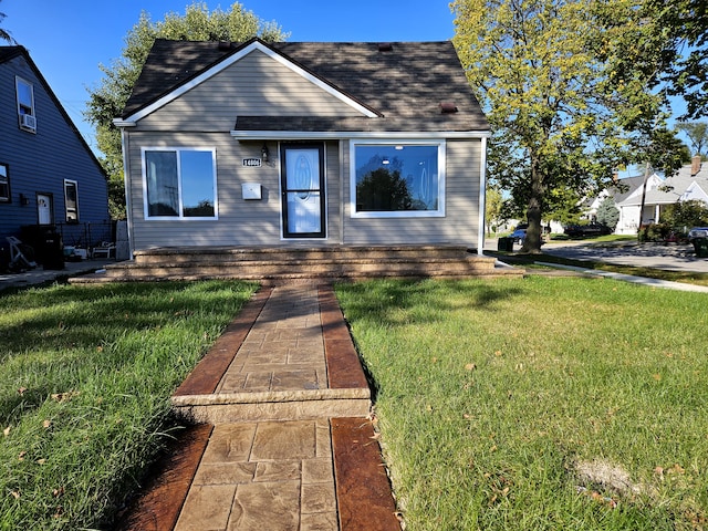 bungalow-style house featuring cooling unit and a front yard