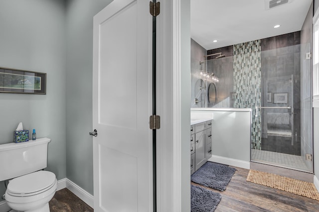 bathroom featuring a shower with door, vanity, wood-type flooring, and toilet