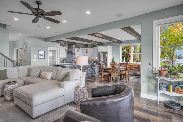 living room featuring beamed ceiling, ceiling fan, and dark hardwood / wood-style flooring