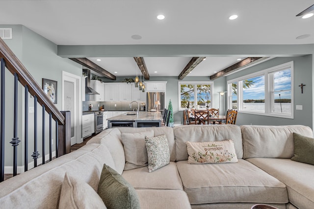 living room with beam ceiling and sink