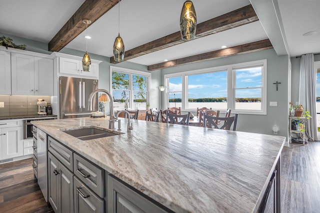 kitchen with white cabinetry, sink, light stone countertops, dark wood-type flooring, and high end refrigerator