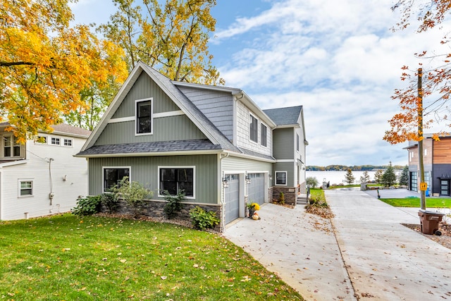 view of front of house with a water view, a garage, and a front yard