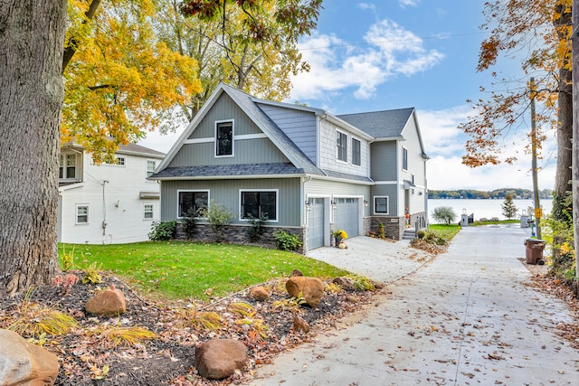 view of front of property with a water view, a front lawn, and a garage