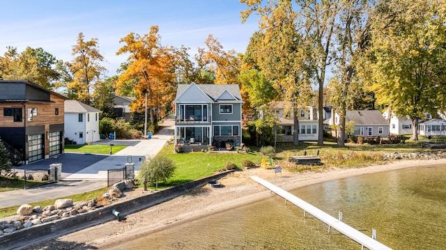 back of house featuring a sunroom and a water view