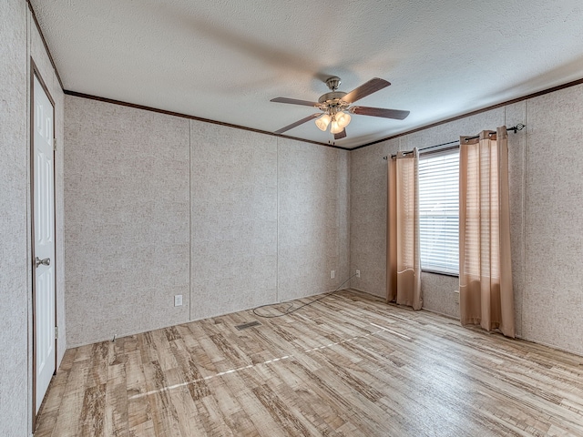 unfurnished bedroom with ceiling fan, ornamental molding, a textured ceiling, and light wood-type flooring