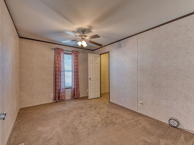 unfurnished room with a textured ceiling, light colored carpet, ceiling fan, and crown molding