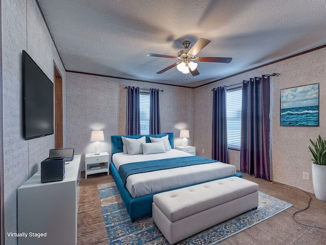 bedroom featuring ceiling fan, a textured ceiling, and ornamental molding