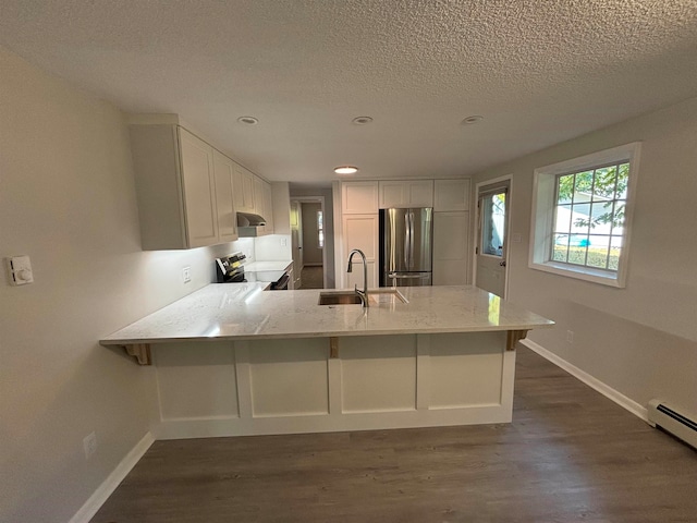 kitchen featuring white cabinetry, sink, stainless steel appliances, dark hardwood / wood-style floors, and kitchen peninsula