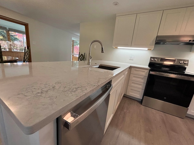 kitchen featuring white cabinetry, sink, stainless steel appliances, kitchen peninsula, and light wood-type flooring