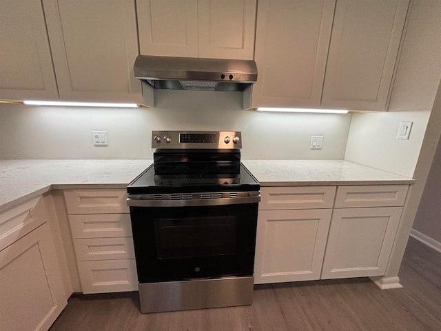 kitchen featuring white cabinets, extractor fan, dark wood-type flooring, and stainless steel electric range