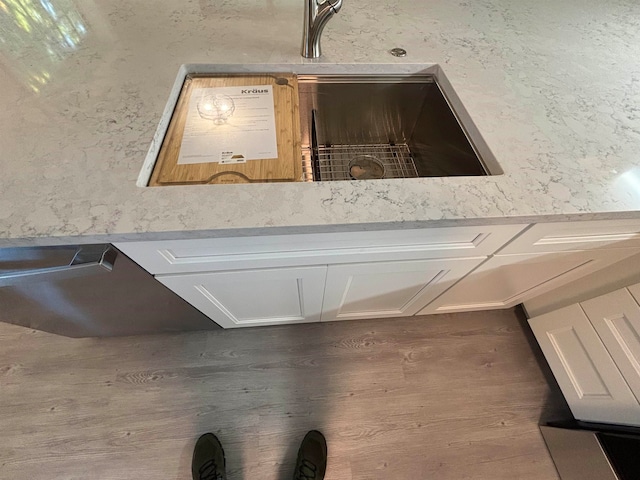 interior details featuring white cabinets, dark hardwood / wood-style flooring, and light stone countertops