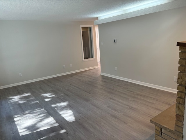 unfurnished living room with a textured ceiling and dark hardwood / wood-style floors