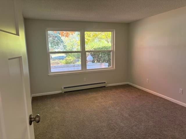 carpeted empty room with baseboard heating and a textured ceiling