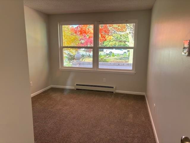 carpeted empty room with a textured ceiling and a baseboard heating unit