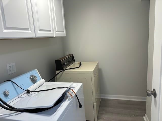 laundry room featuring separate washer and dryer, cabinets, and dark hardwood / wood-style floors