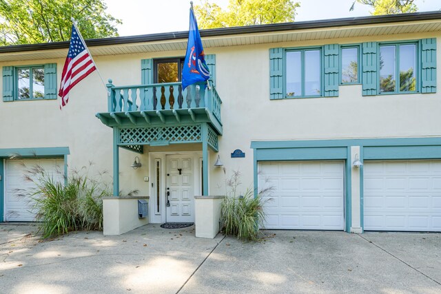 5876 Dunham Ln, Stevensville, MI 49127 - view of front facade with a garage, stucco siding, and concrete driveway