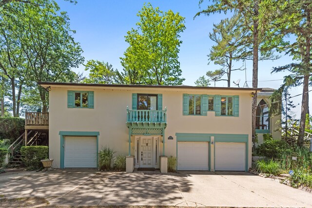 5876 Dunham Ln, Stevensville, MI 49127 - view of front of house with an attached garage, stucco siding, concrete driveway, and stairs