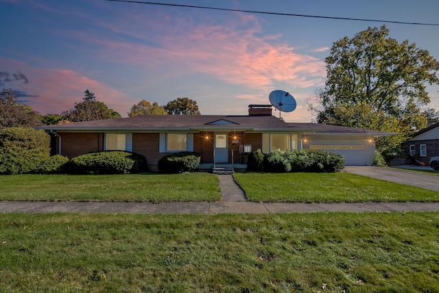 ranch-style house featuring a lawn and a garage