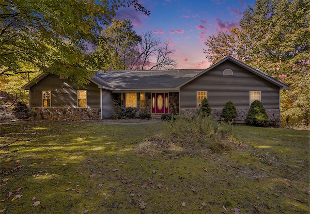 ranch-style home featuring a lawn