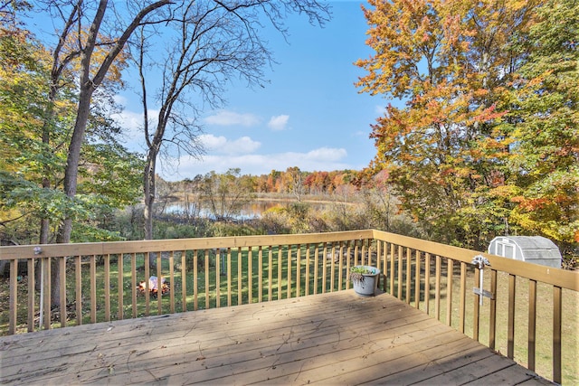 deck featuring a water view and a storage shed