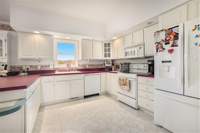 kitchen with sink, white cabinets, and white appliances