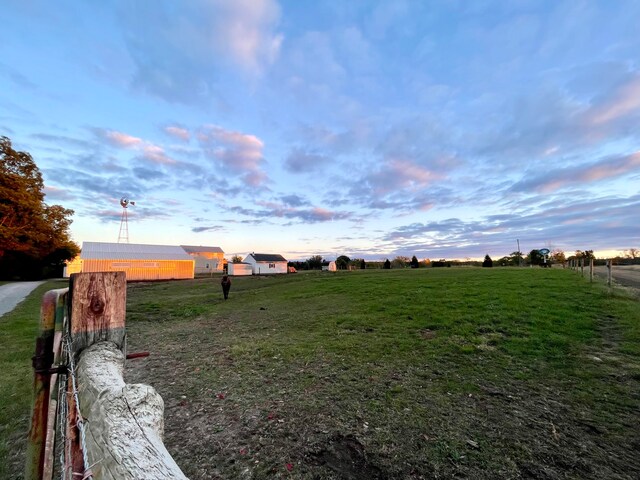 yard at dusk with a rural view