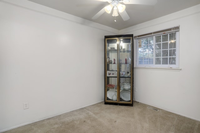 empty room with ceiling fan and light colored carpet