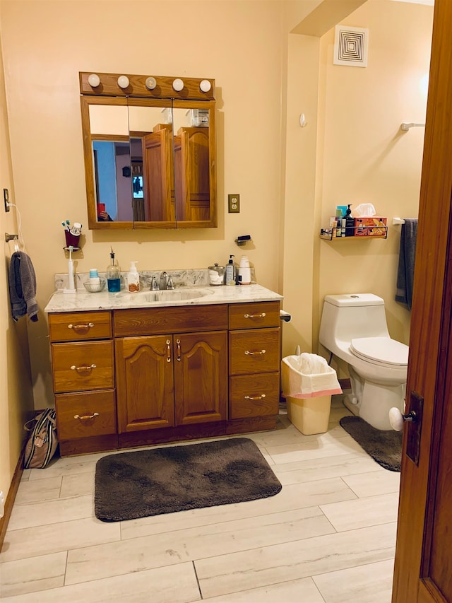 bathroom with hardwood / wood-style floors, vanity, and toilet