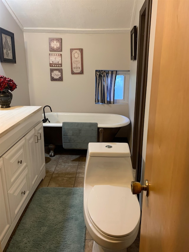 bathroom with tile patterned floors, toilet, a bathtub, vanity, and ornamental molding