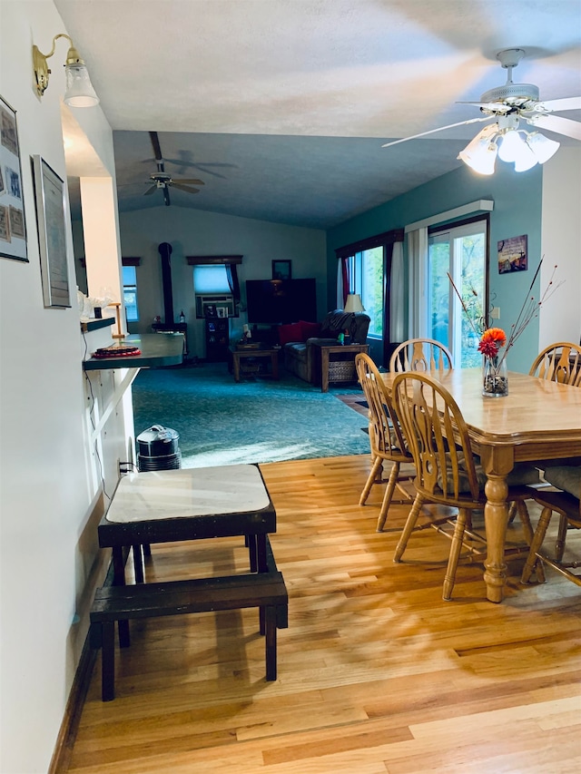 dining room featuring vaulted ceiling and light wood-type flooring