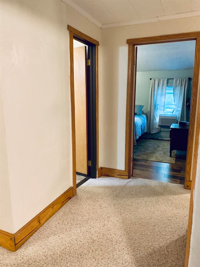 hall with hardwood / wood-style flooring and crown molding