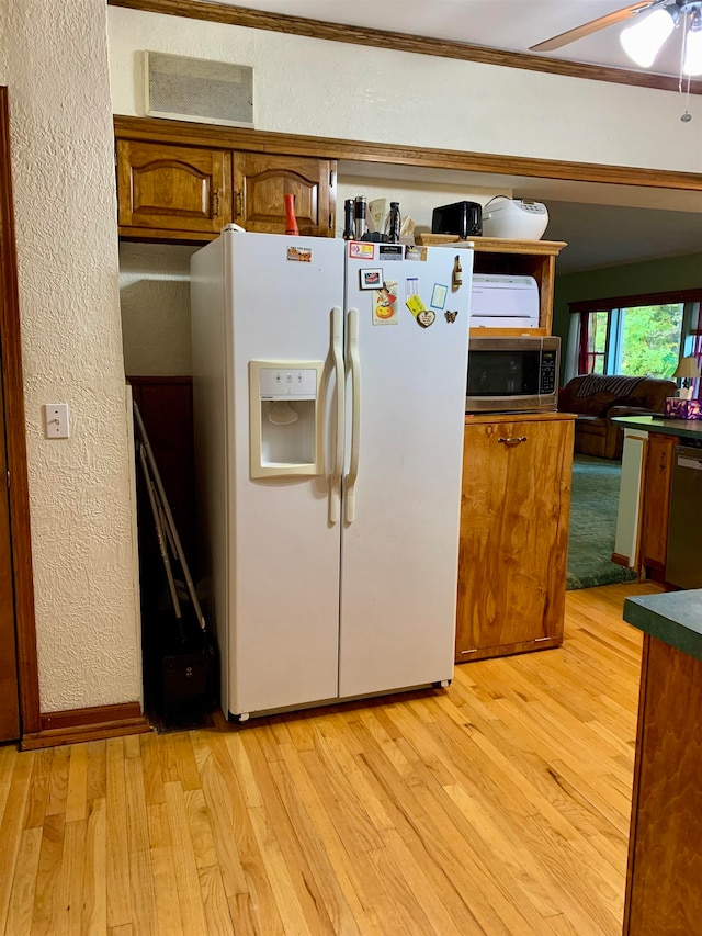 kitchen featuring ceiling fan, light wood-type flooring, and stainless steel appliances