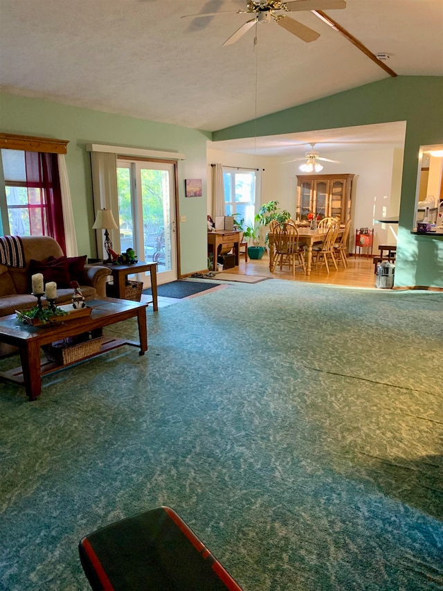 living room featuring ceiling fan, wood-type flooring, and vaulted ceiling