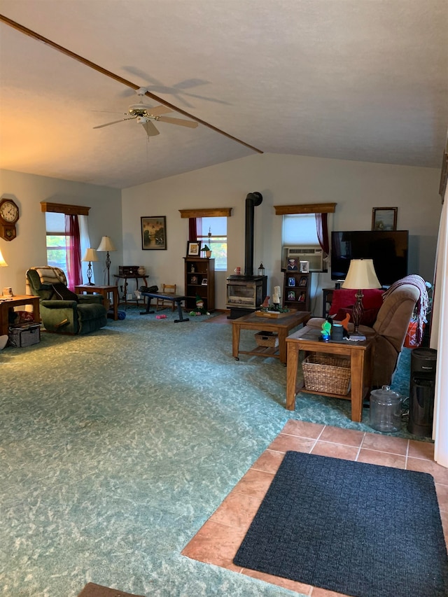 tiled living room with ceiling fan, a wood stove, and vaulted ceiling