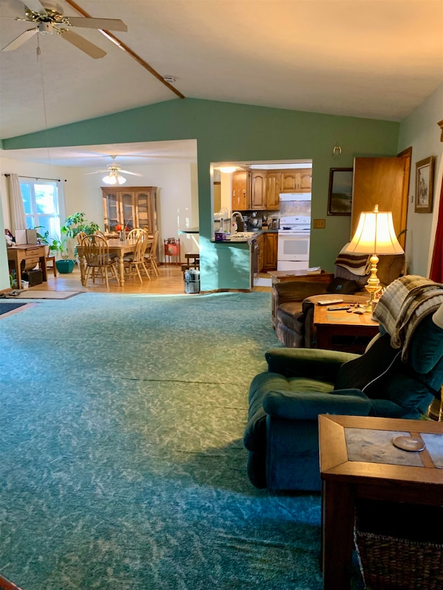 living room with hardwood / wood-style floors, vaulted ceiling, ceiling fan, and sink