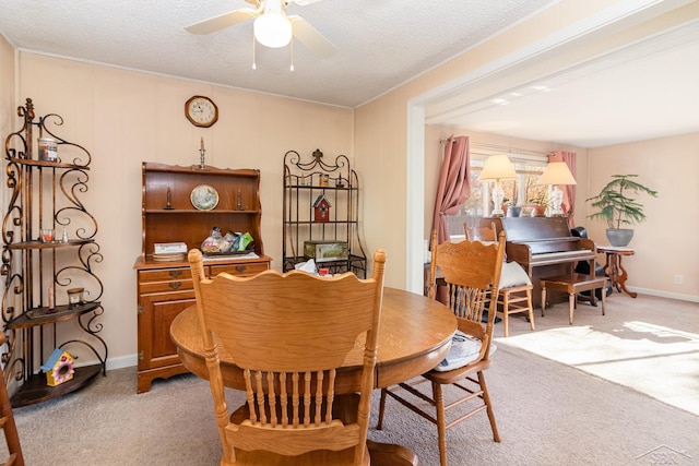 dining room featuring a textured ceiling, ceiling fan, and light carpet