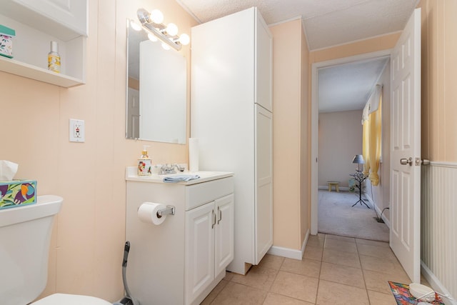 bathroom with tile patterned floors, vanity, a textured ceiling, and toilet