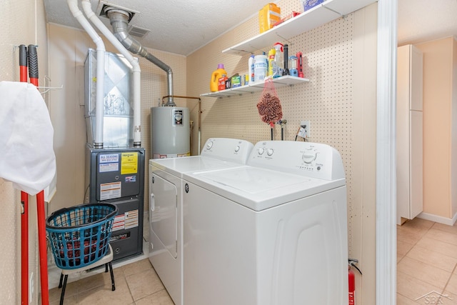 laundry area featuring light tile patterned flooring, a textured ceiling, separate washer and dryer, and water heater