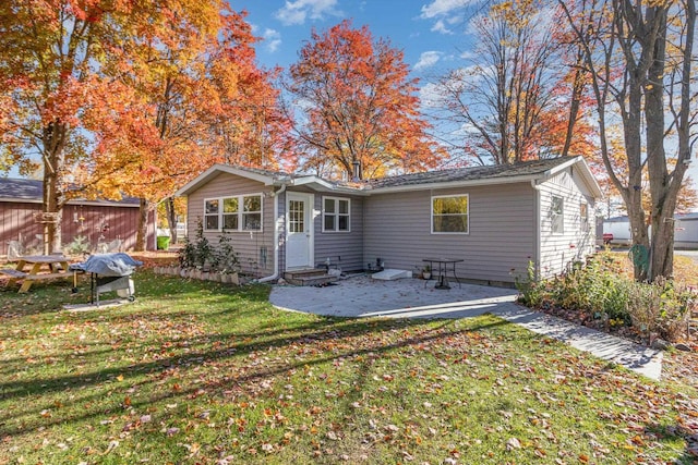 back of property with a patio and a lawn