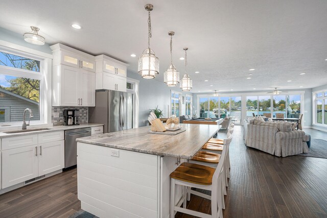 kitchen featuring stainless steel appliances, white cabinetry, a wealth of natural light, and sink